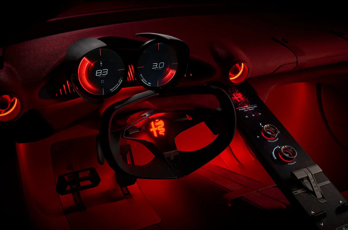 Rood verlicht dashboard van de Alfa Romeo Cuorerosso met twee ronde meters, stuur en middenconsole met draaiknoppen