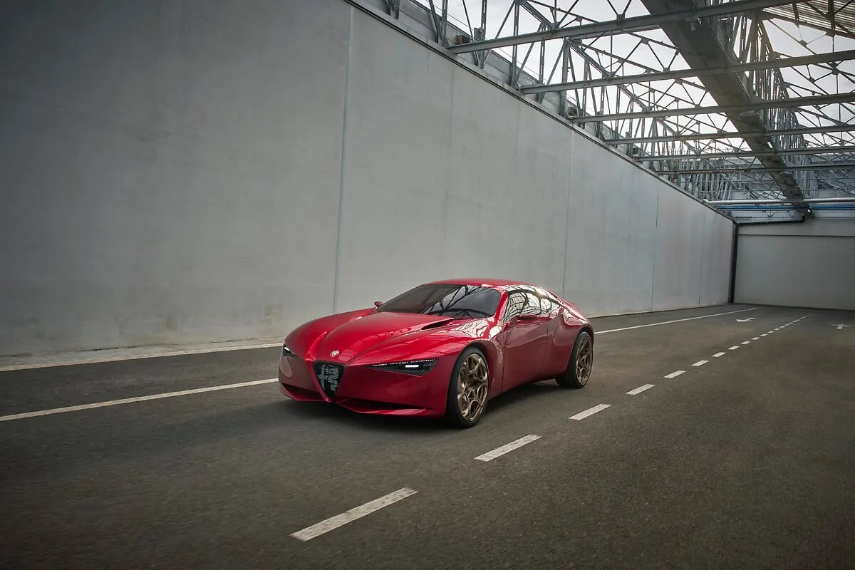 Rode Alfa Romeo Cuorerosso van schuin voren in een lichte hal met stalen dakconstructie