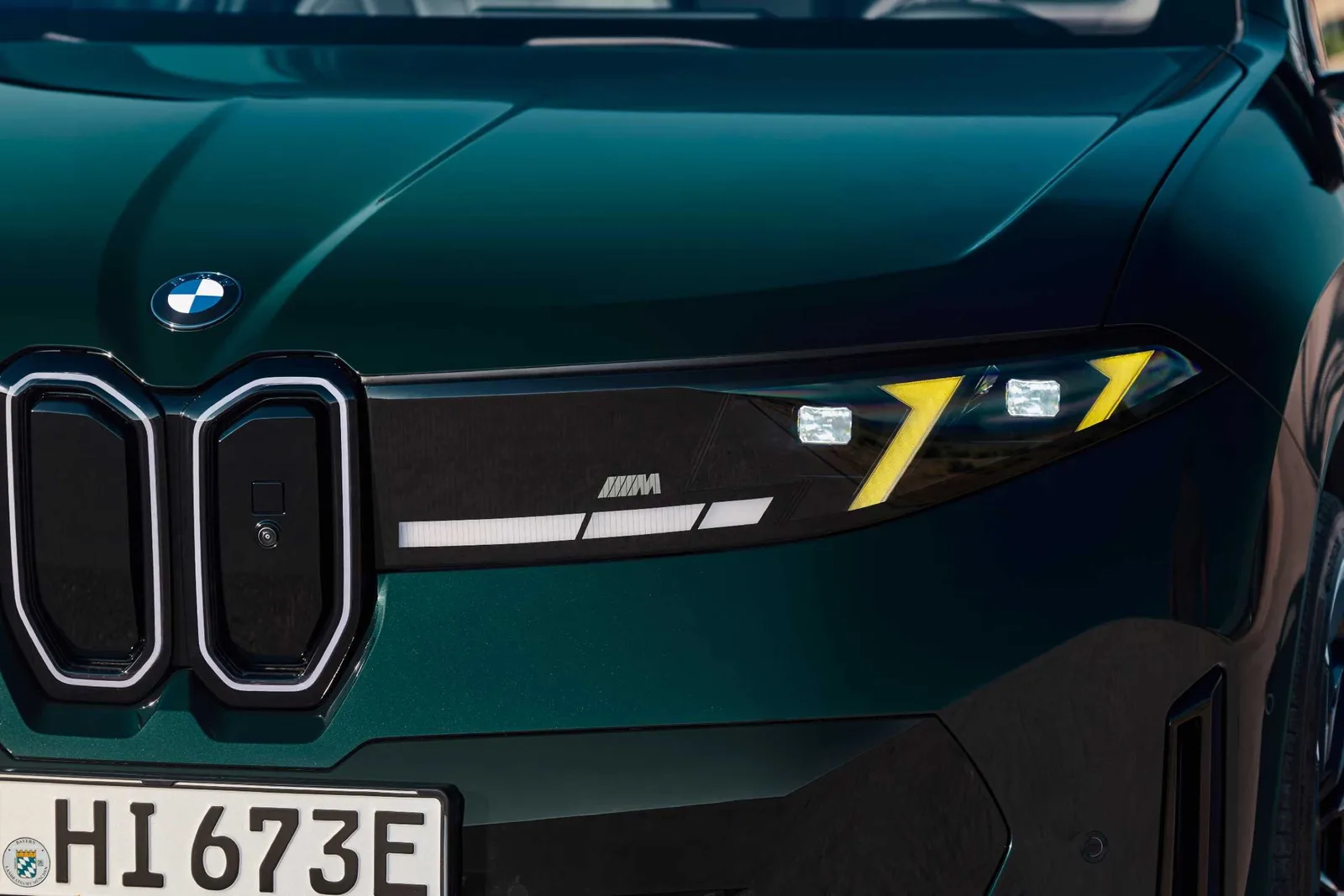 Close-up van de verlichte grille en koplamp van de BMW iX3 M60 xDrive met M-logo