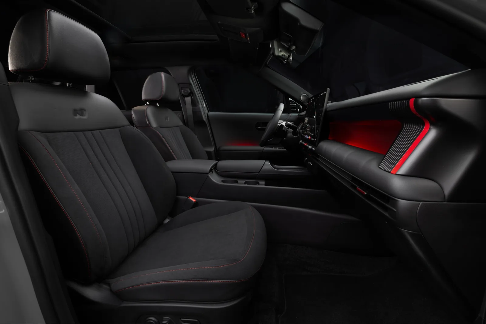 Zwart interieur van de Hyundai Tucson N Line met sportstoelen en rode accenten