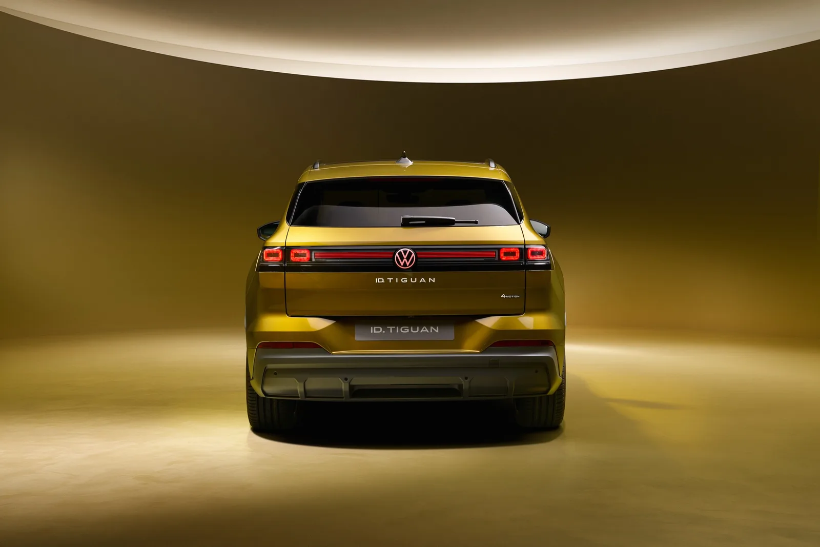Goudkleurige Volkswagen ID. Tiguan Style recht van achteren met doorlopende achterlichtstrook
