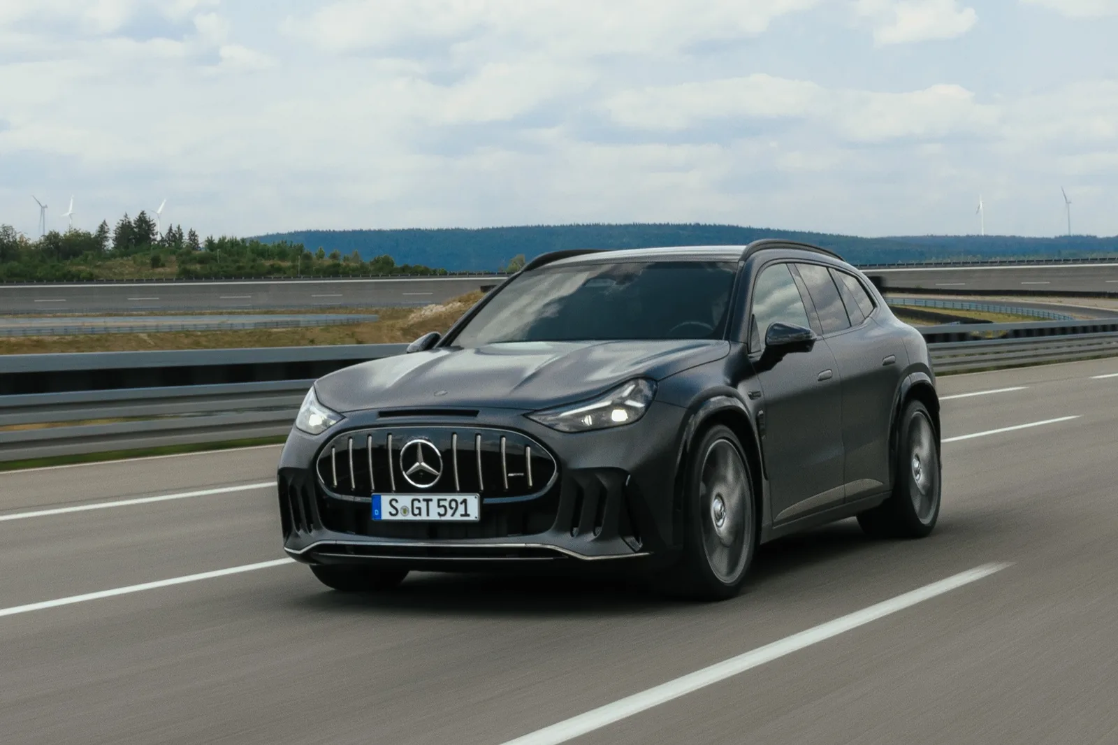 Donkergrijze Mercedes-AMG GT 55 SUV rijdend op een testbaan, van schuin voren