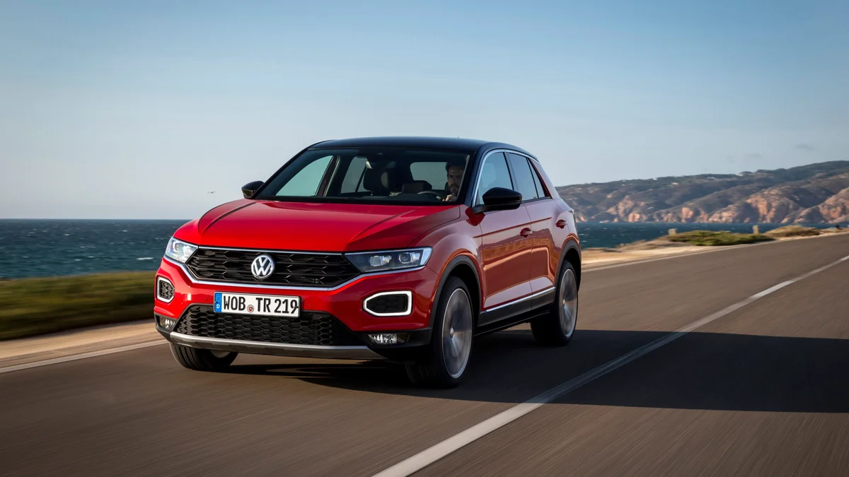 Rode Volkswagen T-Roc van de eerste generatie rijdend over een kustweg