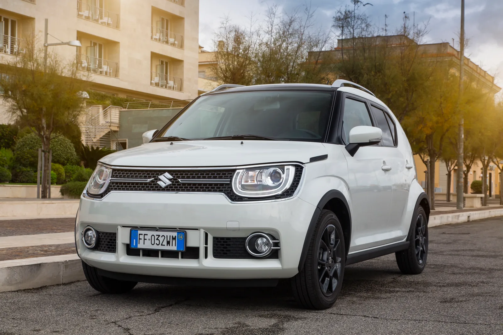 Witte Suzuki Ignis van schuin voren in een straat